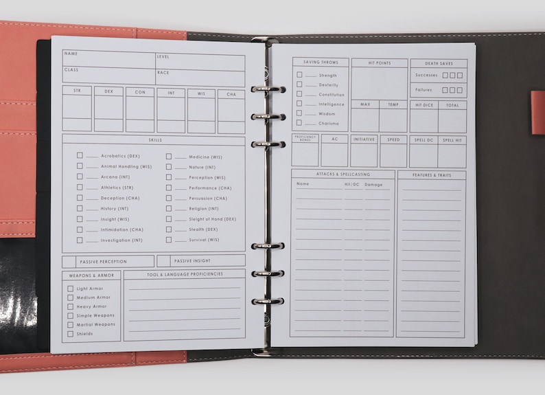 May include: A black and gray leather-bound notebook with a white interior. The notebook is open to a page with a character sheet for a role-playing game. The sheet includes sections for name, class, race, stats, skills, saving throws, hit points, death saves, attacks, and features and traits.