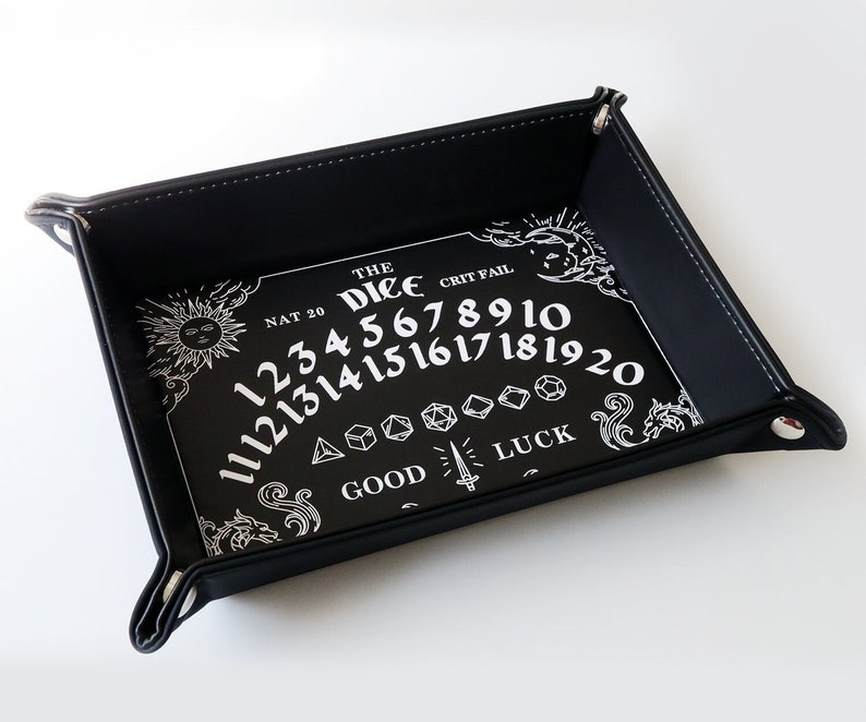 May include: Black leather dice tray with a white design featuring the numbers 1-20, the words "The Dice", "Nat 20", "Crit Fail", "Good Luck", and a sun and moon graphic.
