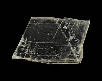 May include: A clear, translucent, and slightly yellow-tinted mineral specimen with a layered, crystalline structure. The mineral has a rough, irregular shape and appears to be composed of multiple, thin, flat layers.