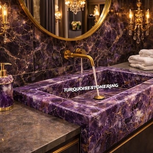 May include: A luxurious bathroom sink and soap dispenser set. The sink is a rectangular basin made of polished purple stone with gold accents. The soap dispenser is a matching purple stone with a gold pump. The text "TURQUOISESTONERING" is visible on the sink.