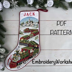 May include: A Christmas stocking with a train design, the word "JACK" in red, and the text "PDF PATTERN" and "EmbroideryWorkshopLV". The stocking features a red and green train with Santa Claus.