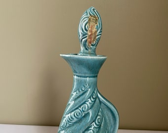 May include: A blue ceramic decanter with a swirl design and a gold label that reads "BONDED BEAM".