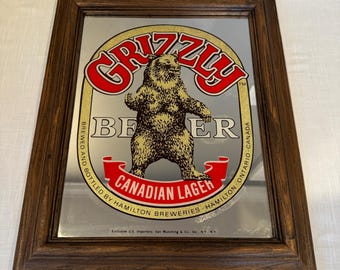 "Seltener 1990er ""Grizzly"" kanadischer Lager, der Bar-Mann-Höhlen-Spiegel annonciert."