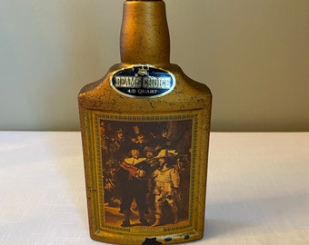 May include: A gold-colored glass bottle with a black plastic stopper. The bottle has a label that says "Beam's Choice 4/5 Quart". The bottle has a picture of a group of people in a painting on the front.