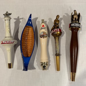 May include: Five vintage beer tap handles.  The handles are made of wood, metal, and ceramic.  The handles feature the logos for Michelob, Bass Ale, Schlitz, and a canoe design.