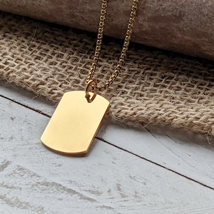 May include: A gold chain necklace with a plain gold rectangular tag pendant.