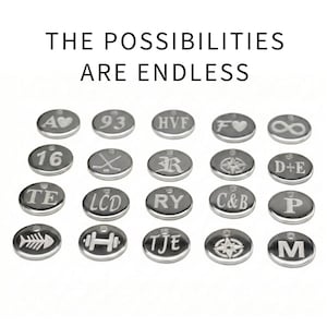 Puede incluir: Una colecci&oacute;n de peque&ntilde;os colgantes grabados de color plateado con varios s&iacute;mbolos y letras. El texto "THE POSSIBILITIES ARE ENDLESS" se muestra encima de los colgantes. Los colgantes incluyen un coraz&oacute;n, un s&iacute;mbolo de infinito y una br&uacute;jula.