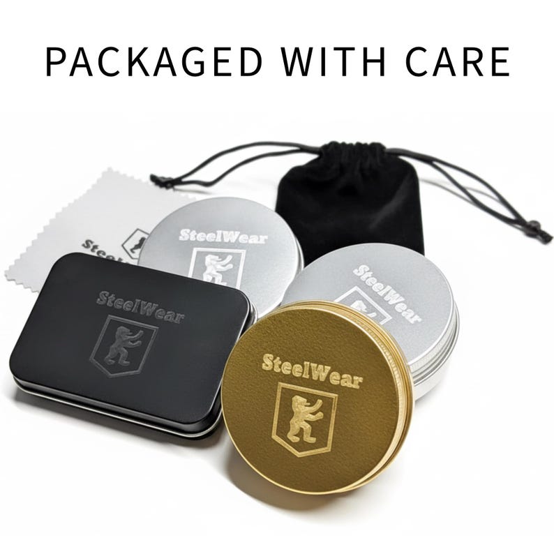 Puede incluir: Un surtido de recipientes met&aacute;licos y una bolsa negra con cord&oacute;n. Los recipientes son plateados, dorados y negros, con el texto "SteelWear" y un logotipo de oso. Tambi&eacute;n se incluye un pa&ntilde;o de limpieza y el texto "PACKAGED WITH CARE".