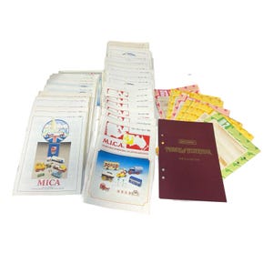 Peut inclure: Une collection de catalogues de voitures miniatures vintage et un classeur bordeaux. Les catalogues présentent des illustrations colorées de voitures et de camions miniatures. Le classeur est intitulé "Models of Yesteryear". La collection est disposée sur une surface blanche.