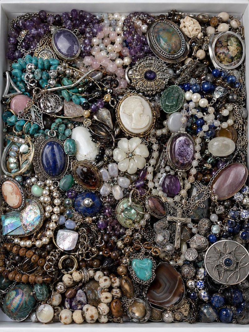 May include: A collection of assorted jewellery pieces including necklaces, bracelets, and brooches featuring various gemstones like turquoise, amethyst, and lapis lazuli, alongside pearls, cameos, and a silver crucifix pendant in a white tray.