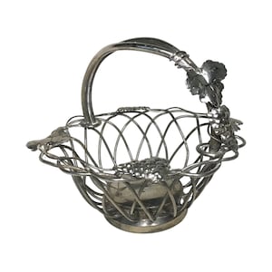Könnte beinhalten: Silberner Drahtkorb mit Traubenranken-Design. Der Korb hat einen Griff und einen runden Boden.