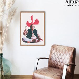 May include: A framed print of a man sitting in a meditative pose with a large red Arabic letter "Jal" above his head. The print is on a white background and has a wooden frame.