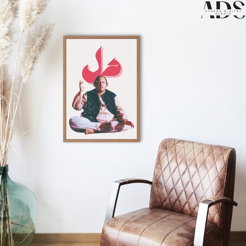 May include: A framed print of a man sitting in a meditative pose with a large red Arabic letter "Jal" above his head. The print is on a white background and has a wooden frame.