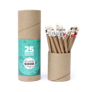 Pode incluir: Um conjunto de 25 canetas de papel plant&aacute;veis em um tubo de papel&atilde;o marrom. O tubo tem um r&oacute;tulo que diz "Do More Good Than Just Less Bad". As canetas s&atilde;o organizadas em um tubo de papel&atilde;o marrom. As canetas s&atilde;o etiquetadas com diferentes tipos de sementes, como cenouras, feij&otilde;es e tomates.