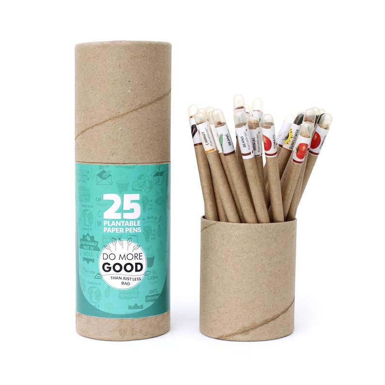 Pode incluir: Um conjunto de 25 canetas de papel plant&aacute;veis em um tubo de papel&atilde;o marrom. O tubo tem um r&oacute;tulo que diz "Do More Good Than Just Less Bad". As canetas s&atilde;o organizadas em um tubo de papel&atilde;o marrom. As canetas s&atilde;o etiquetadas com diferentes tipos de sementes, como cenouras, feij&otilde;es e tomates.