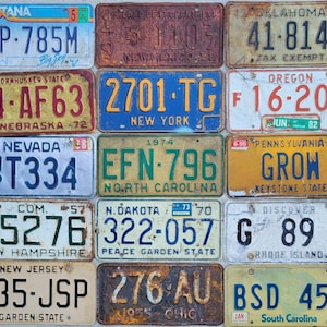 May include: A collection of vintage license plates from different states in the US. The plates are in various colors and feature different state names, license numbers, and slogans. Some of the plates are worn and faded, while others are in better condition.