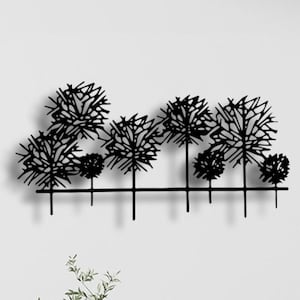 May include: Black metal wall art featuring a stylized silhouette of a row of trees. The trees are abstract and have a delicate, whimsical design.