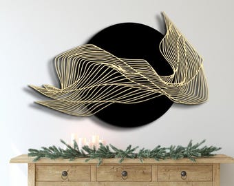 May include: Gold metal wall art with a black circular background and a flowing, abstract design.