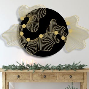 Peut inclure: Une décoration murale en métal noir et or avec un design circulaire présentant des formes et des lignes abstraites. La décoration a une esthétique moderne et minimaliste.
