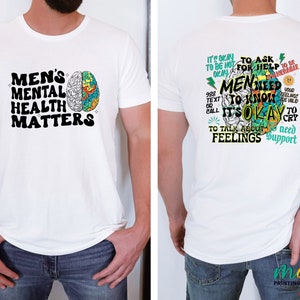 Może przedstawiać: Biała koszulka z grafiką m&oacute;zgu z przodu i tekstem "Men's Mental Health Matters". Z tyłu koszulka ma grafikę m&oacute;zgu z tekstem "It's okay to ask for help. Men need to know it's okay to talk about feelings. You need support. 988 Text or Call."