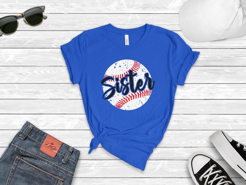 May include: A royal blue t-shirt with a white baseball graphic and the word "Sister" in black text.