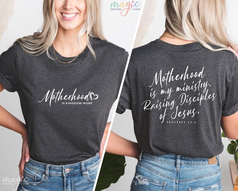 K&ouml;nnte beinhalten: Ein dunkelgraues T-Shirt mit wei&szlig;em Text, der auf der Vorderseite "Motherhood is Kingdom Work" und auf der R&uuml;ckseite "Motherhood is my ministry. Raising Disciples of Jesus. Proverbs 22:6" lautet.