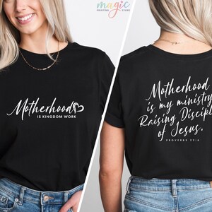 K&ouml;nnte beinhalten: Schwarzes T-Shirt mit wei&szlig;em Text, der auf der Vorderseite "Motherhood is Kingdom Work" und auf der R&uuml;ckseite "Motherhood is my ministry. Raising Disciples of Jesus. Proverbs 22:6" lautet.