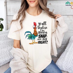 May include: A white t-shirt with a cartoon rooster and the text "y'all realize I'm gonna SNAP one day RIGHT?"