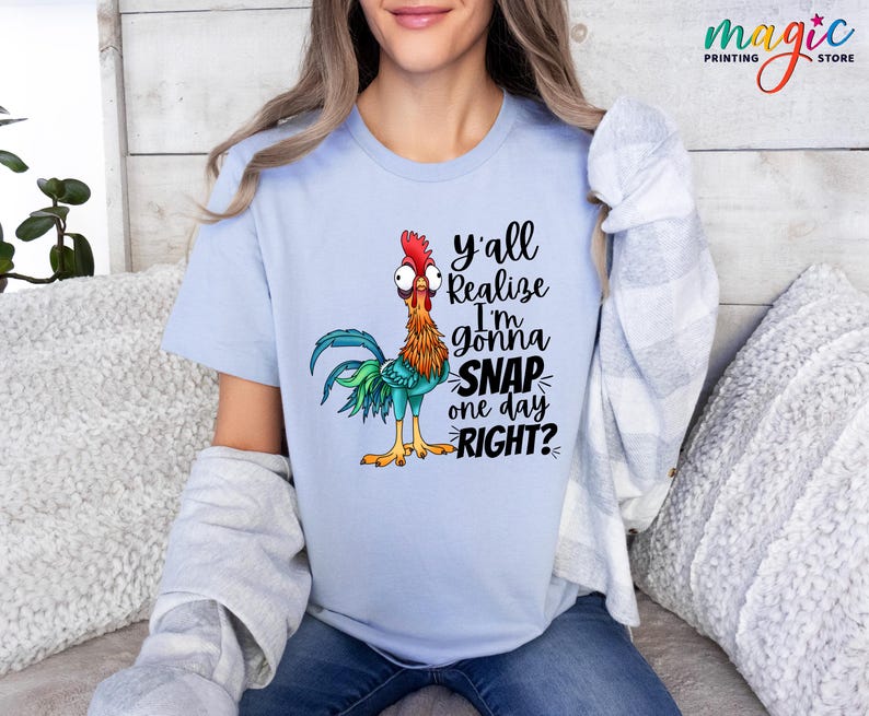 May include: A light blue t-shirt with a cartoon rooster and the text "y'all realize I'm gonna SNAP one day RIGHT?"
