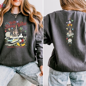 May include: Charcoal grey sweatshirt with a vibrant graphic of Mickey Mouse, a monorail, and a castle with fireworks. The text reads "Every World is a Disney World" and "The Happiest Place on Earth". The back has a vertical design with Mickey and other Disney icons.