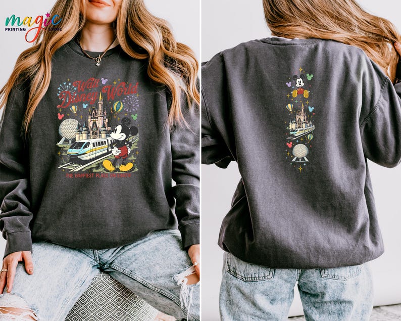 May include: Charcoal grey sweatshirt with a vibrant graphic of Mickey Mouse, a monorail, and a castle with fireworks. The text reads "Every World is a Disney World" and "The Happiest Place on Earth". The back has a vertical design with Mickey and other Disney icons.