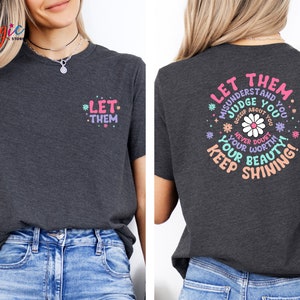 May include: A dark gray t-shirt with a pink and blue graphic print on the back that says "Let them misunderstand you, judge you, gossip about you. Never doubt your worth. Keep your beauty shining!" and a smaller print on the front that says "Let them".