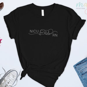 May include: Black t-shirt with a white graphic design that says "NICU RN" with a stylized line drawing of a baby.