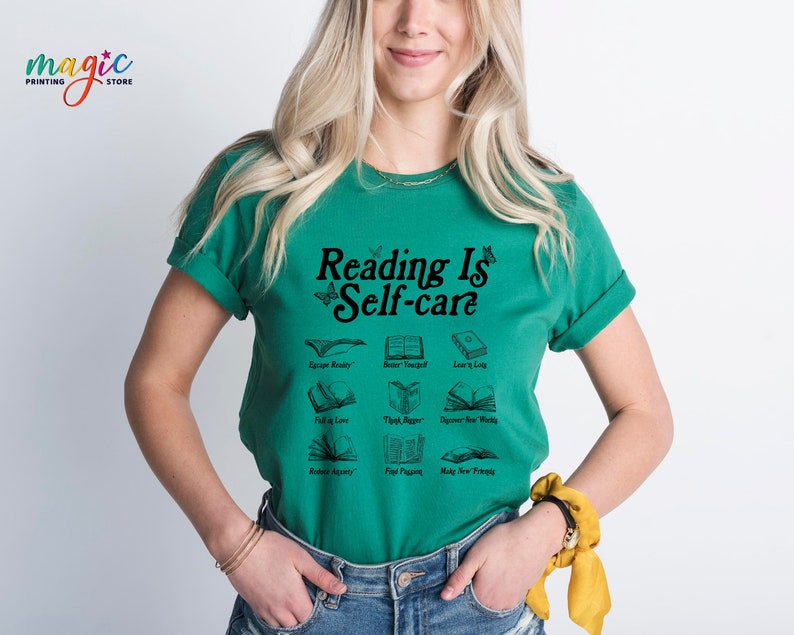 May include: A green t-shirt with the text "Reading Is Self-care" in black. The shirt features a graphic of open books with different phrases, including "Escape Reality", "Better Yourself", "Learn Lots", "Fall in Love", "Think Deeper", "Discover New Worlds", "Reflect Aparty", "Find Peace", and "Make New Friends".