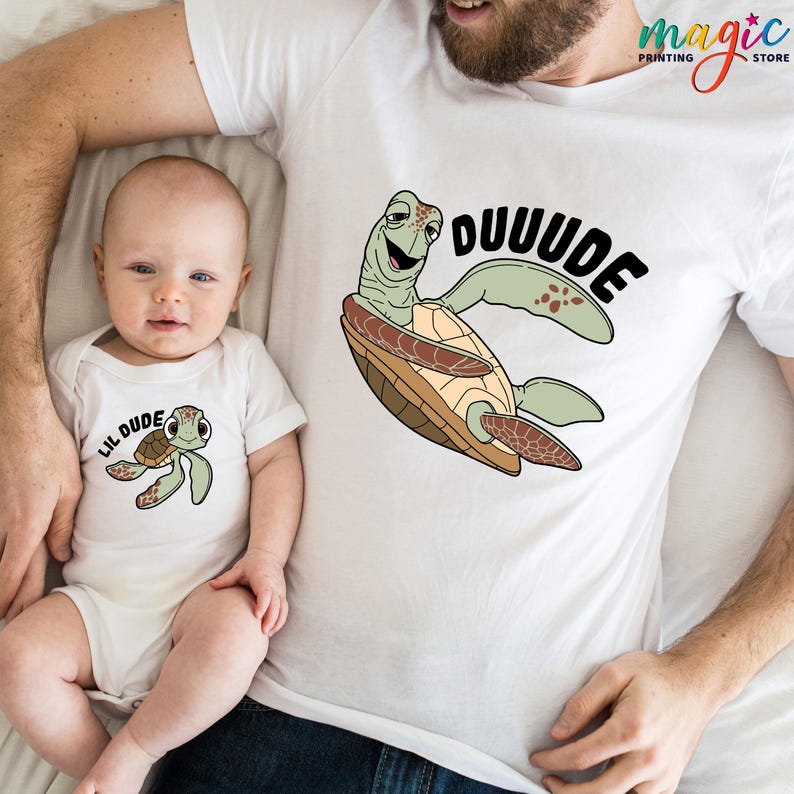May include: White t-shirts and baby bodysuit with matching turtle graphic. The adult shirt features a large turtle with the word "DUUUDE" in black. The baby bodysuit has a smaller turtle and the words "LIL DUDE".