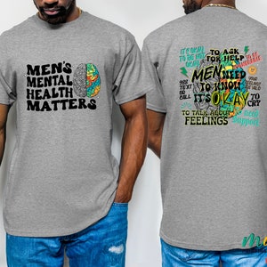 Może przedstawiać: Szary T-shirt z kolorową grafiką m&oacute;zgu i tekstem "Men's Mental Health Matters" z przodu. Z tyłu T-shirt ma kolorową grafikę m&oacute;zgu z tekstem "W porządku jest prosić o pomoc. Mężczyźni muszą wiedzieć, że w porządku jest rozmawiać o uczuciach. Potrzebujesz wsparcia."