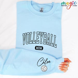 May include: Light blue sweatshirt with the text "Volleyball Mom" and a volleyball graphic. The name "Chloe" is written in cursive below the volleyball.