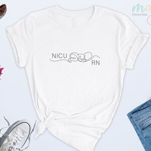 May include: White t-shirt with a black line drawing of a baby and the text "NICU RN".