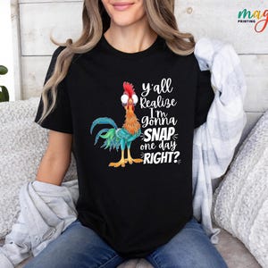 May include: A black t-shirt with a colorful rooster illustration and the text "y'all realize I'm gonna snap one day right?"