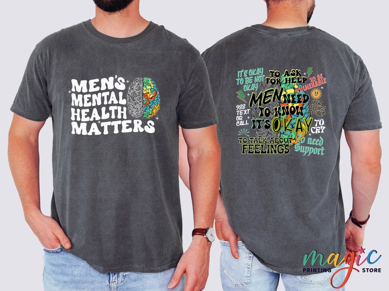 Może przedstawiać: Szary t-shirt z białym nadrukiem z przodu, kt&oacute;ry głosi "Men's Mental Health Matters" i kolorową grafiką m&oacute;zgu. Z tyłu t-shirtu znajduje się kolorowa grafika z tekstem "It's okay to ask for help. Men need to know it's okay to talk about feelings. To need support."