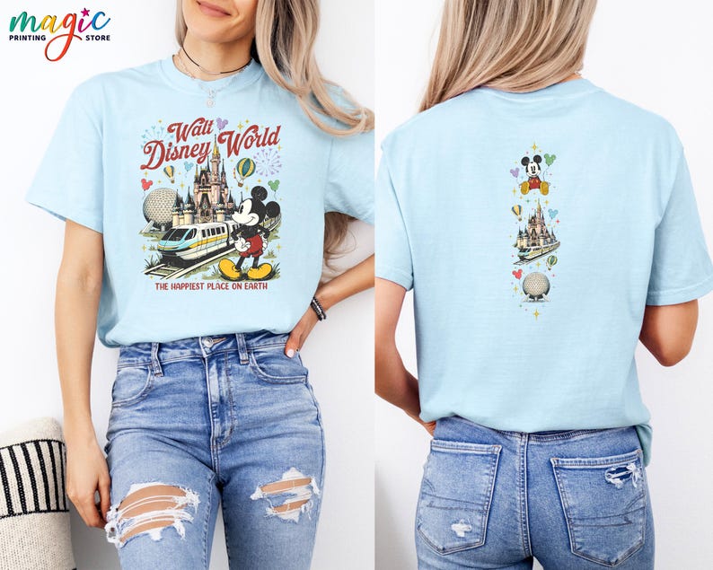 May include: Pale blue t-shirt with a vibrant graphic of Walt Disney World, including Mickey Mouse, a monorail, and Cinderella's castle. The front of the tee reads "Walt Disney World" and "The Happiest Place on Earth."