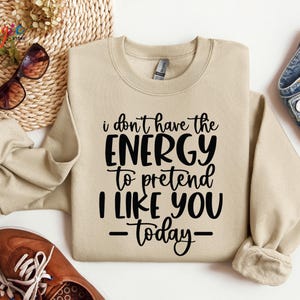 Puede incluir: Una sudadera de color beige con texto negro que dice "No tengo la energ&iacute;a para fingir que me gustas - hoy - "
