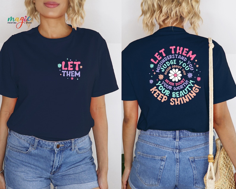 May include: A navy blue t-shirt with the text "Let them misunderstand you, judge you, gossip about you, never doubt your worth, your beauty, keep shining!" in a circle with a pink daisy in the center. The text is in a pink, blue, and green font.