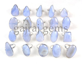 Könnte beinhalten: Eine Sammlung von 18 Silberringen mit blauen Achat-Edelsteinen. Die Ringe haben verschiedene Formen, darunter oval, tropfenförmig und rechteckig. Die Edelsteine sind hellblau mit weißen und grauen Mustern.