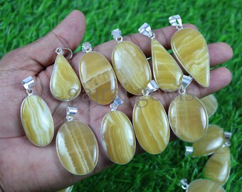 Può includere: Una collezione di 10 ciondoli in agata gialla e bianca con montature in argento. I ciondoli sono di forma ovale e a goccia.