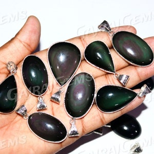 May include: A collection of ten black obsidian gemstone pendants with silver bail settings. The pendants are in various shapes, including teardrop and oval. The stones have a dark, iridescent sheen.