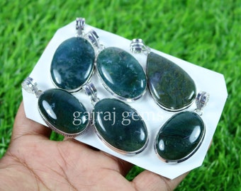 May include: Six green agate gemstone pendants with silver settings. The pendants are oval and teardrop shaped. The stones have a mottled green and brown pattern.