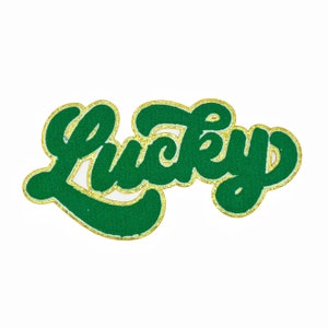 Op de afbeelding: Groen vilt "Lucky" patch met gouden glitterrand.