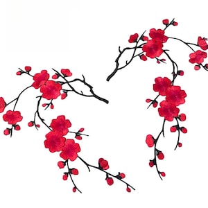 Peut inclure: Deux branches de fleurs de cerisier rouges avec des tiges noires. Les branches sont disposées en forme de cœur.