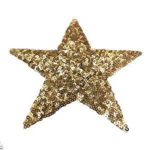 May include: A gold star-shaped patch made of sequins. The star is about 7.5 cm wide.